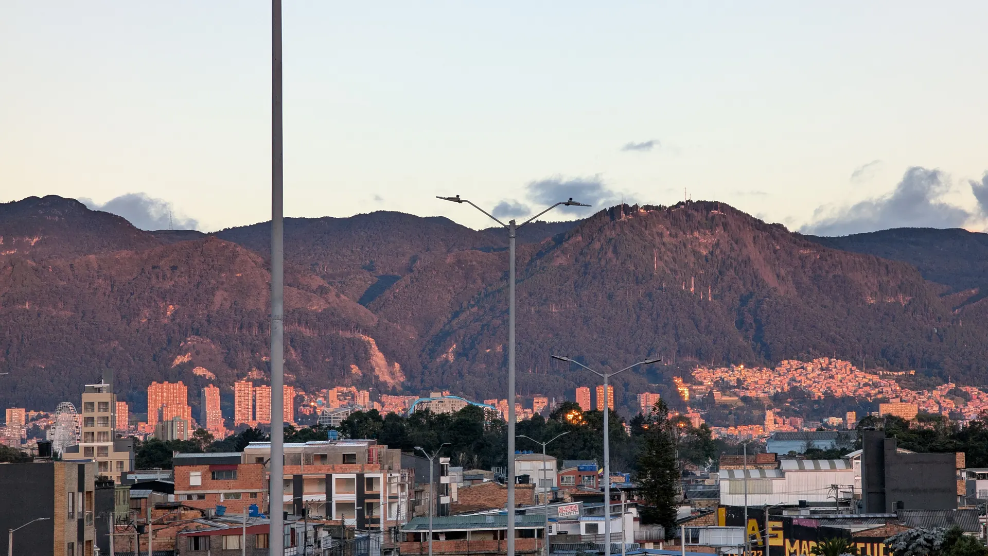 Los cerros orientales de Bogotá al atardecer, con Monserrate iluminado sobre la ciudad